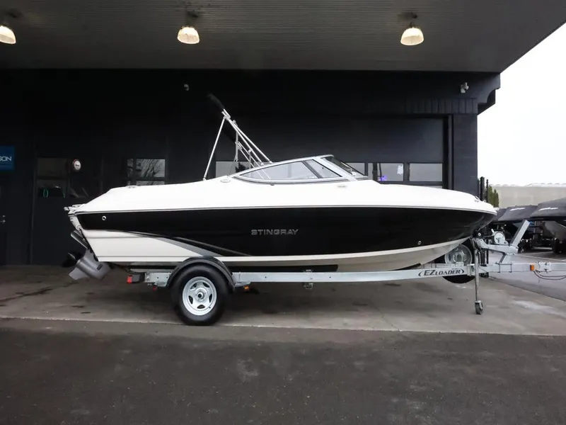 Slide: The Image of 2015 Stingray 198LX boat on trailer, parked indoors under ceiling lights. - 1