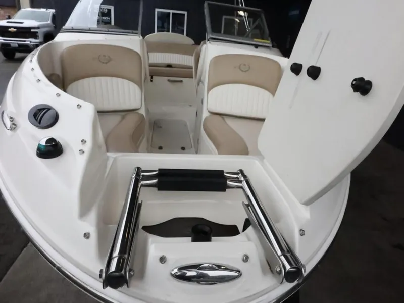 Slide: The Image of 2015 Stingray 198LX boat interior with beige and white seating, open hatch, and stainless steel ladder. - 12