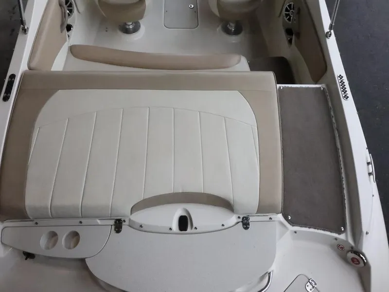 Slide: The Image of 2015 Stingray 198LX boat interior with beige and white seating, cup holders, and storage compartments. - 14
