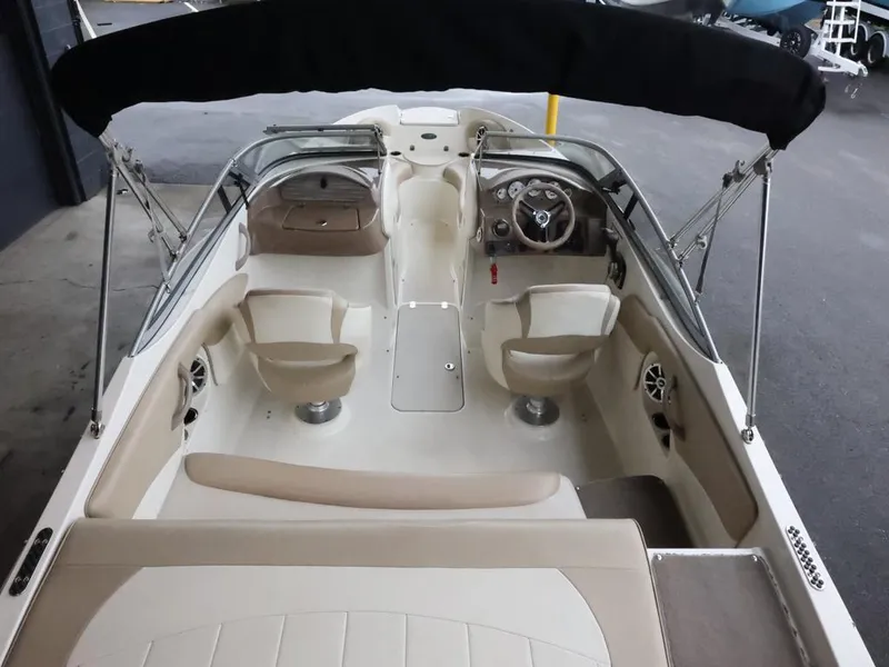 Slide: The Image of 2015 Stingray 198LX boat interior with seating and steering wheel, featuring a black canopy. - 15