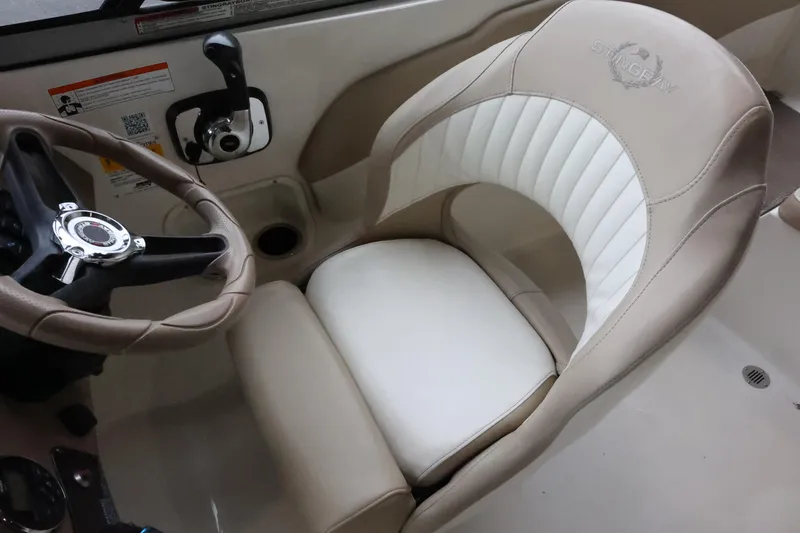 Slide: The Image of 2015 Stingray 198LX boat interior with beige and white captain's seat and steering wheel. - 19