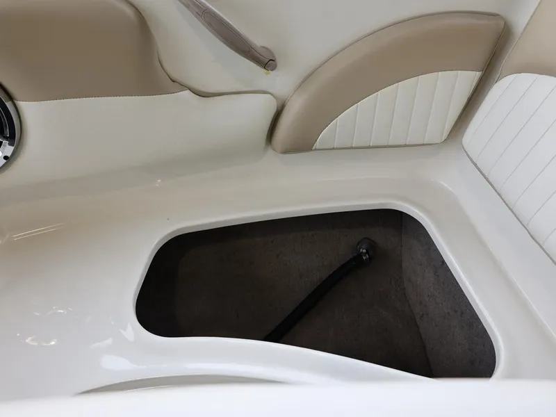 Slide: The Image of Interior storage compartment of a 2015 Stingray 198LX boat, featuring beige and white upholstery. - 26