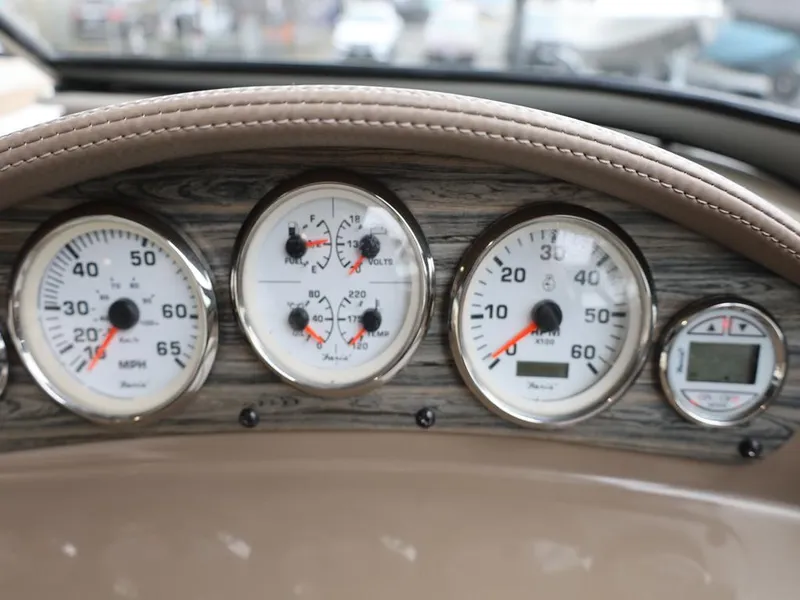 Slide: The Image of Dashboard of a 2015 Stingray 198LX boat with multiple gauges and wood paneling. - 30