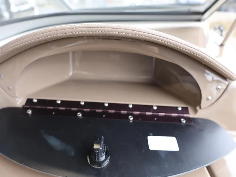 Slide: The Image of Dashboard of a 2015 Stingray 198LX boat with control knob and storage area. - 33