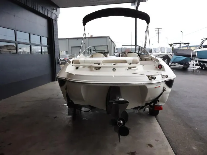 Slide: The Image of 2015 Stingray 198LX boat, rear view, parked in a marina with other boats. - 7