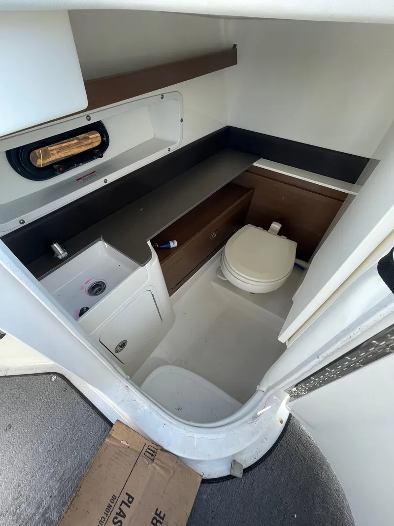 Slide: The Image of 2016 Sea Ray 290 Sundeck interior bathroom with sink, toilet, and storage. - 10