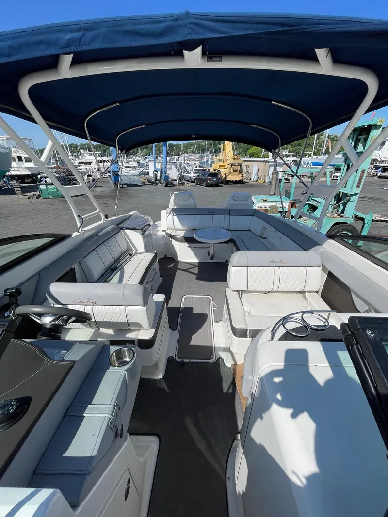 Slide: The Image of 2016 Sea Ray 290 Sundeck boat with blue canopy, docked at marina. - 15