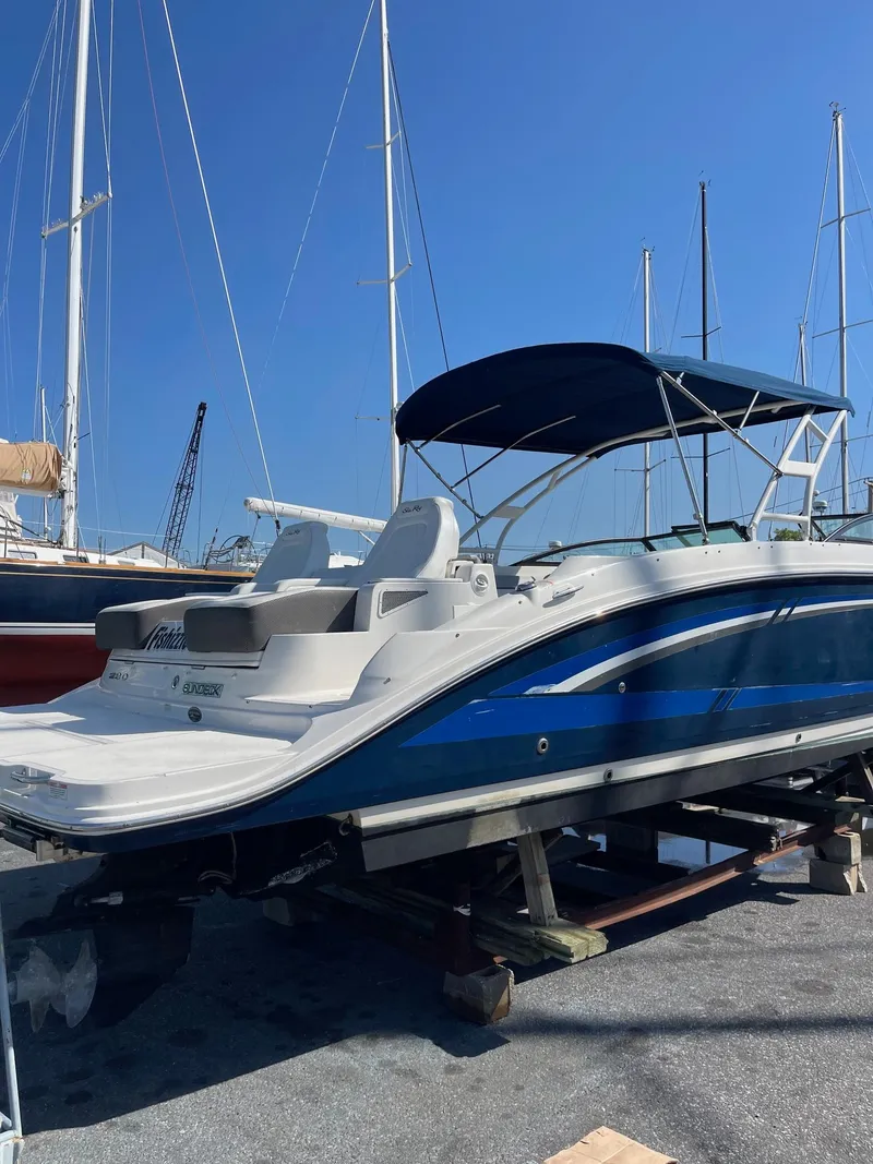 Slide: The Image of 2016 Sea Ray 290 Sundeck boat with blue hull, docked under clear sky. - 8