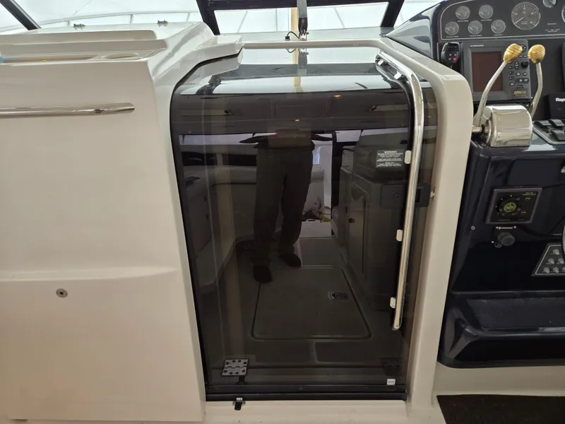 Slide: The Image of 2002 Tiara Yachts 3500 Open Hardtop cockpit with glass door and control panel. - 10