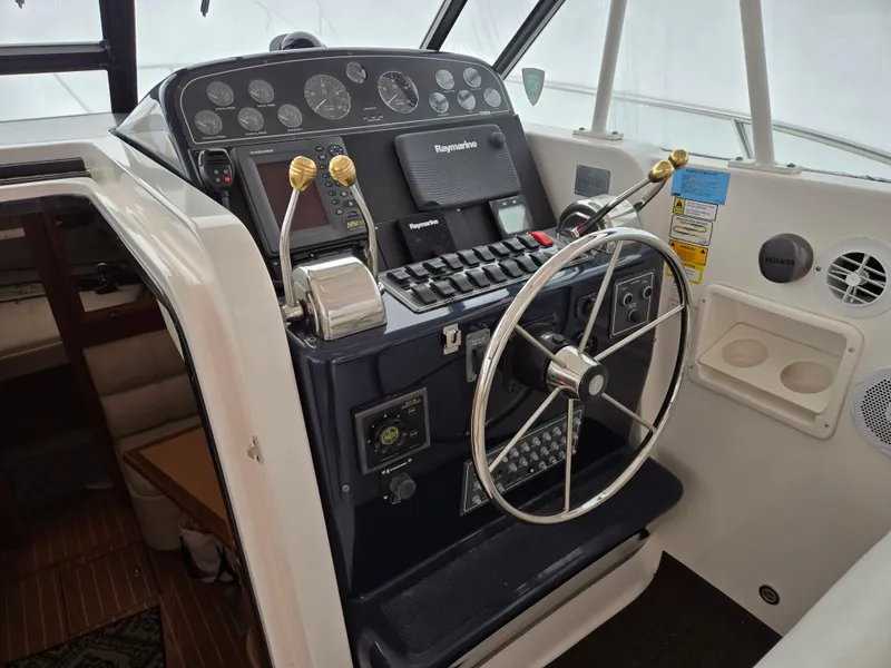 Slide: The Image of 2002 Tiara Yachts 3500 Open Hardtop helm with steering wheel and control panel. - 14