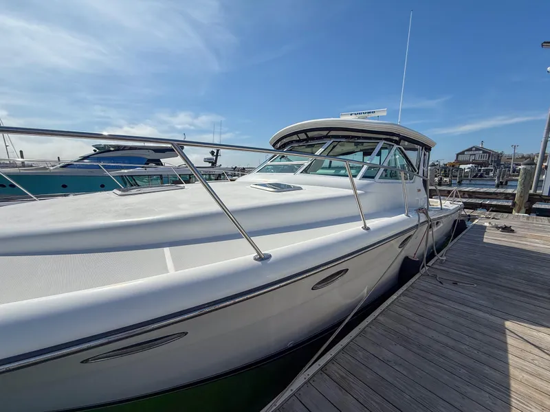 Slide: The Image of 2002 Tiara Yachts 3500 Open Hardtop docked at marina under clear blue sky. - 2