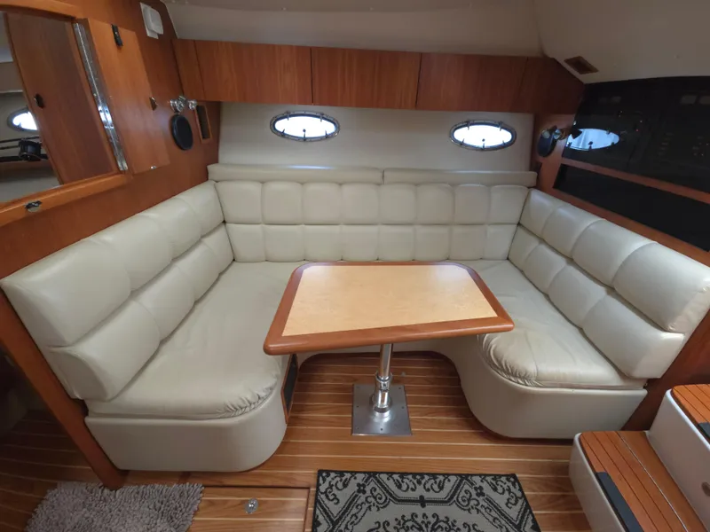 Slide: The Image of 2002 Tiara Yachts 3500 Open Hardtop interior with plush seating and wooden table. - 22