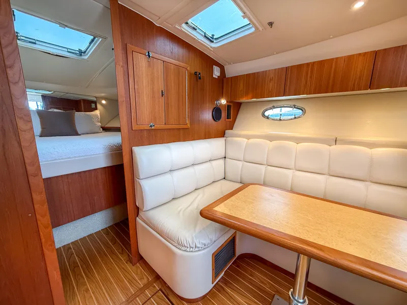 Slide: The Image of 2002 Tiara Yachts 3500 Open Hardtop interior with cozy seating and wooden accents. - 23