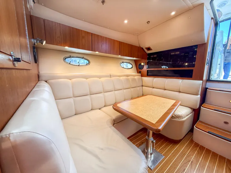 Slide: The Image of 2002 Tiara Yachts 3500 Open Hardtop interior with plush seating and wooden accents. - 24