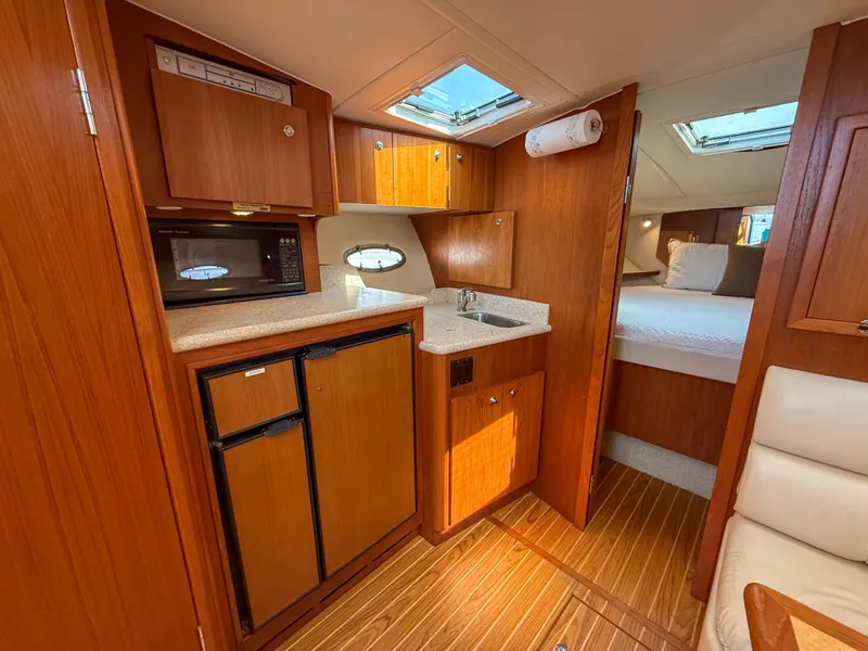 Slide: The Image of 2002 Tiara Yachts 3500 Open Hardtop interior with kitchenette and cozy sleeping area. - 27