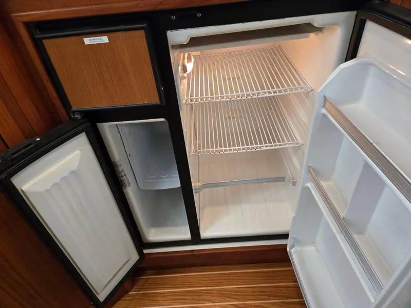 Slide: The Image of 2002 Tiara Yachts 3500 Open Hardtop refrigerator interior with wooden paneling. - 29