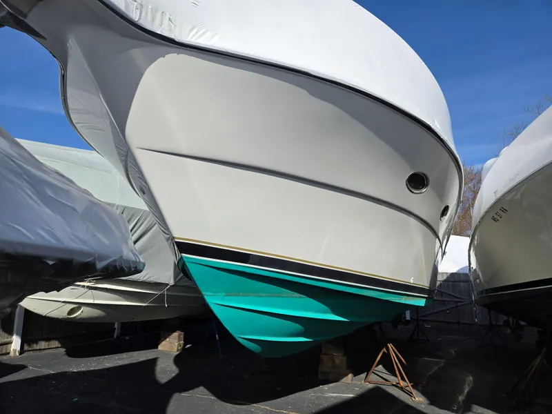 Slide: The Image of 2002 Tiara Yachts 3500 Open Hardtop, white hull with teal bottom, stored outdoors. - 5