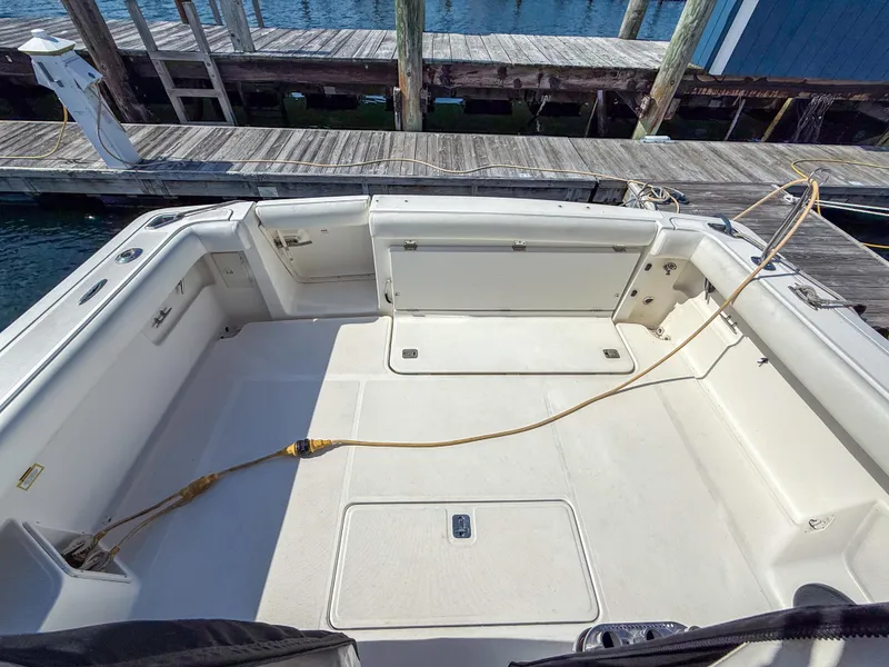 Slide: The Image of 2002 Tiara Yachts 3500 Open Hardtop boat deck at marina, featuring spacious seating area. - 6