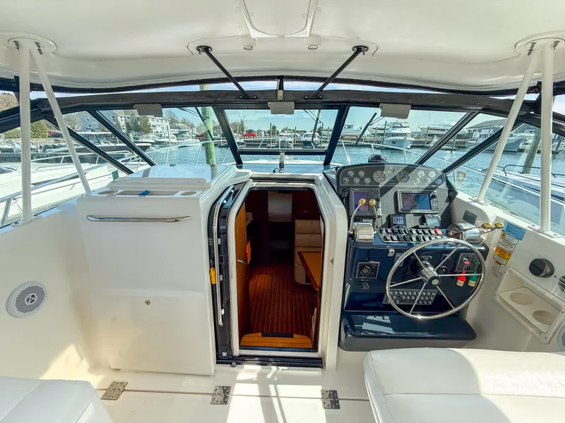 Slide: The Image of 2002 Tiara Yachts 3500 Open Hardtop helm with modern controls and marina view. - 9
