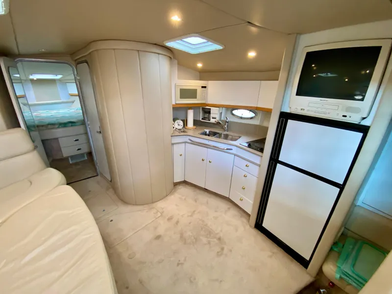 Slide: The Image of 1998 Formula 41 PC yacht interior with kitchenette, TV, and seating area. - 19