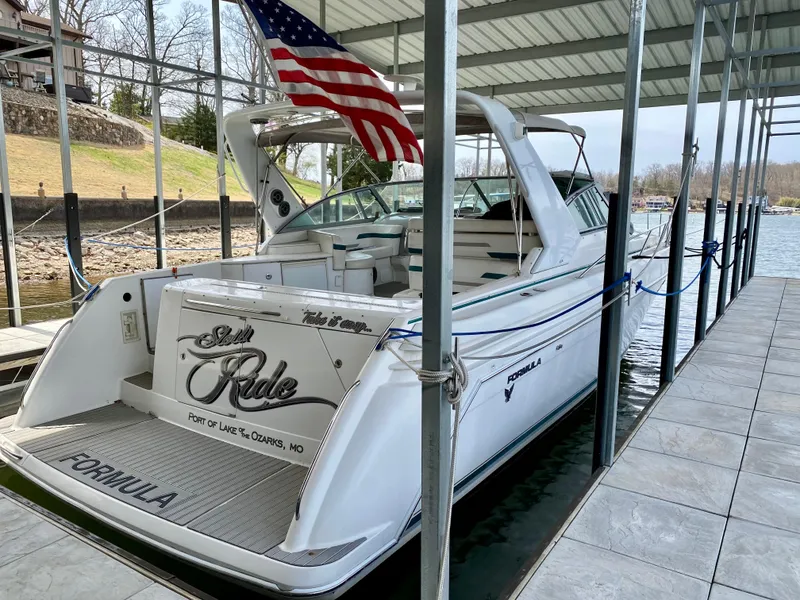 Slide: The Image of 1998 Formula 41 PC yacht docked, featuring American flag and sleek design. - 2