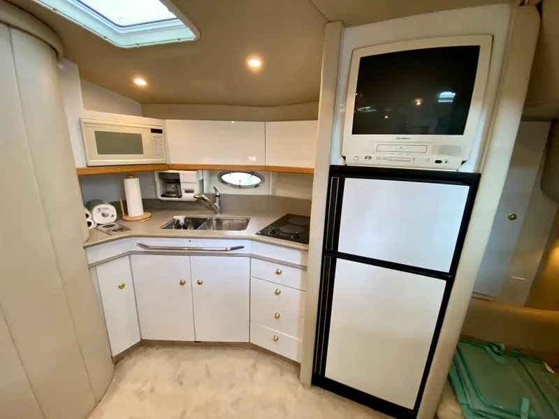 Slide: The Image of 1998 Formula 41 PC yacht kitchen with microwave, sink, stove, and TV above refrigerator. - 20