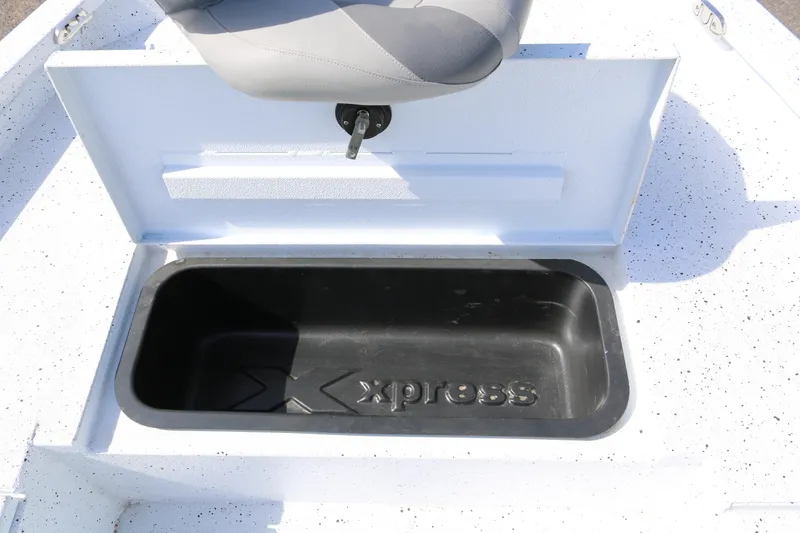 Slide: The Image of 2022 Xpress H22B boat storage compartment with seat, open lid, and logo. - 16