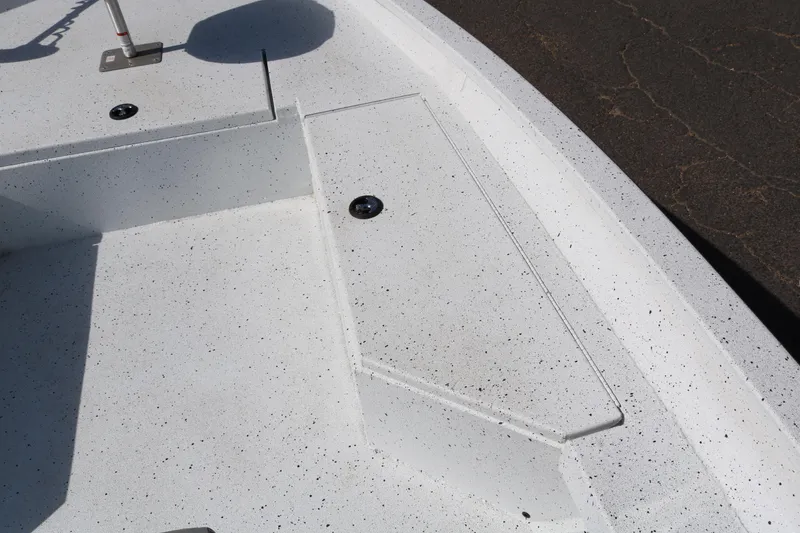 Slide: The Image of 2022 Xpress H22B boat deck with white speckled surface and storage compartments. - 17