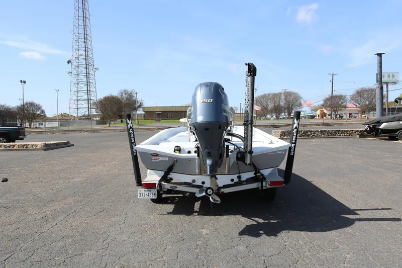 Slide: The Image of 2022 Xpress H22B boat with outboard motor, parked in a lot under clear skies. - 6