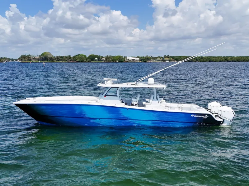 The Image of 2023 Freeman 47 boat on water, blue hull, clear sky, calm sea. - 0