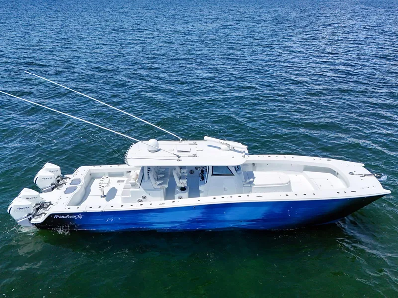 Slide: The Image of 2023 Freeman 47 boat on open water, featuring a sleek blue and white design. - 13