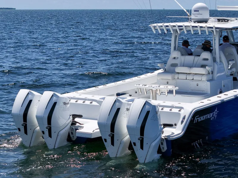 Slide: The Image of 2023 Freeman 47 boat with four powerful outboard engines on open water. - 19