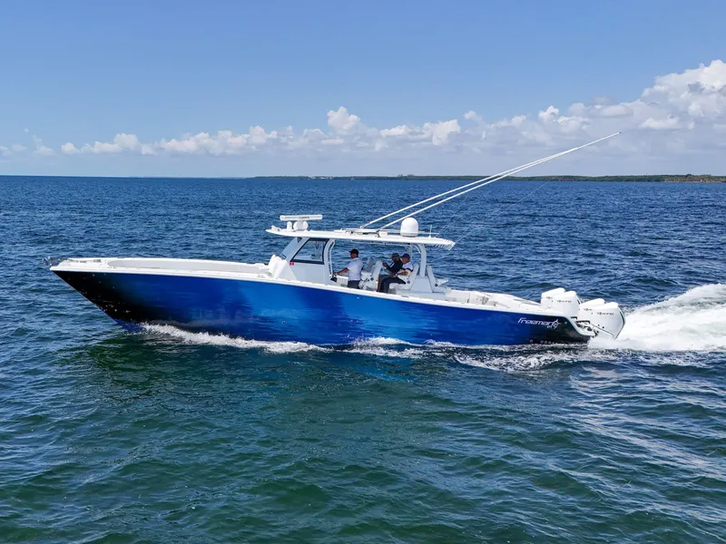 Slide: The Image of 2023 Freeman 47 boat cruising on open water under clear blue skies. - 2