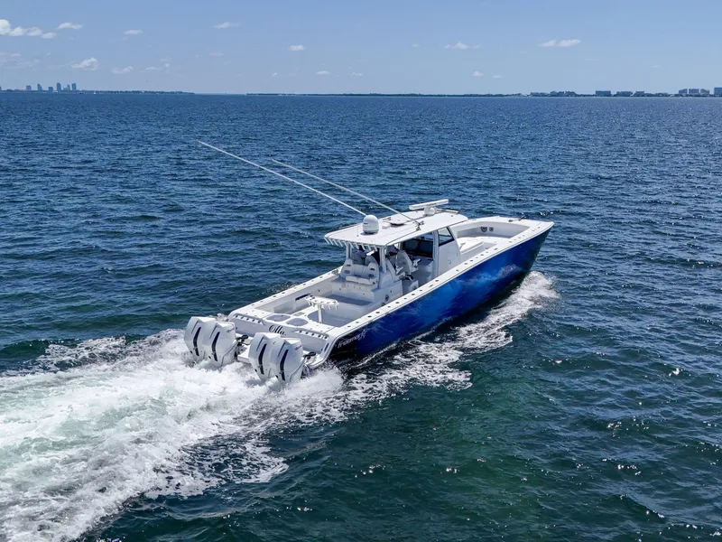 Slide: The Image of 2023 Freeman 47 boat cruising on open water with city skyline in background. - 26