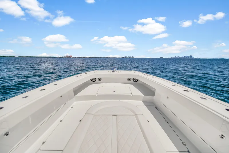 Slide: The Image of Freeman 47 boat on open water, 2023 model, clear sky, and distant shoreline. - 29