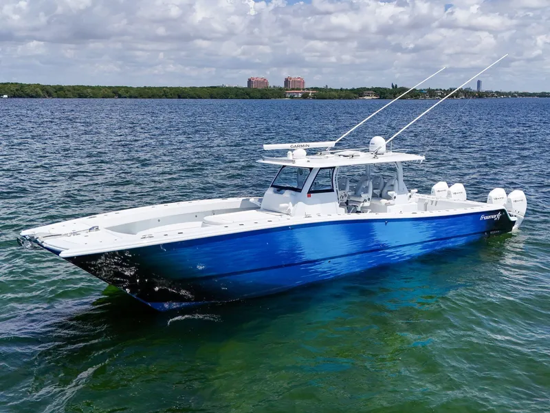 Slide: The Image of 2023 Freeman 47 boat on clear blue water under a partly cloudy sky. - 3