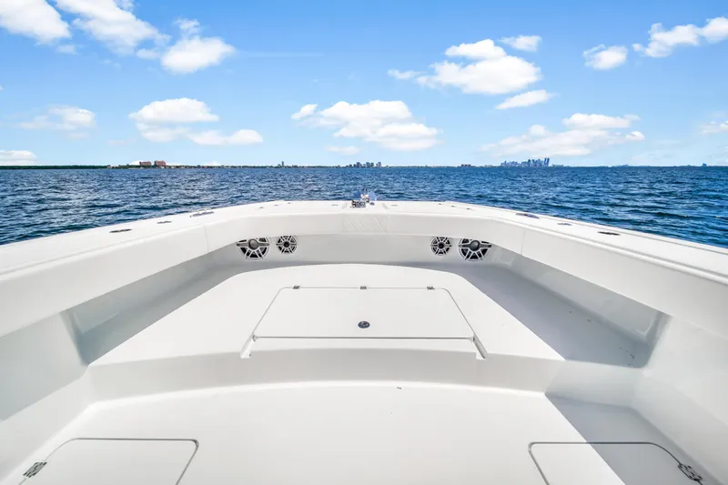 Slide: The Image of Freeman 47 boat deck overlooking ocean, 2023 model, clear sky, distant city skyline. - 30