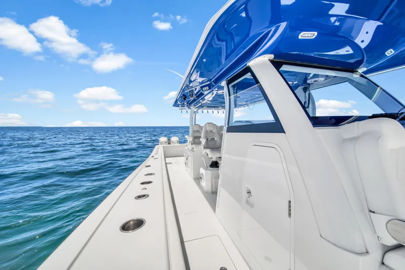 Slide: The Image of Freeman 47 boat on open sea, 2023 model, featuring sleek design and blue canopy. - 34