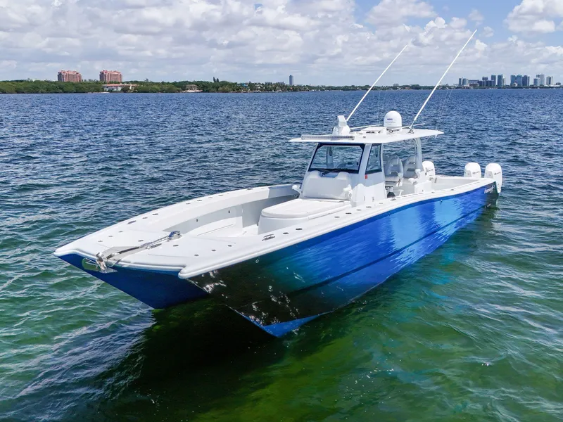 Slide: The Image of 2023 Freeman 47 boat on calm water, featuring a sleek blue and white design. - 4