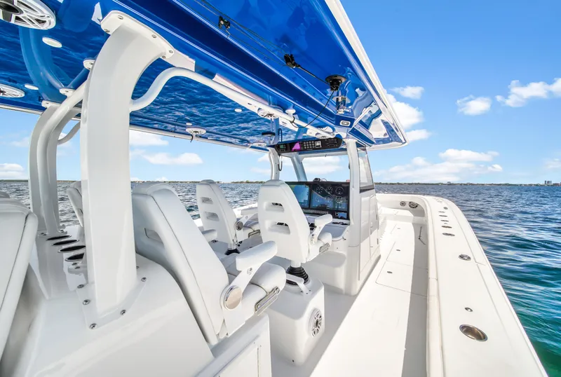 Slide: The Image of 2023 Freeman 47 boat with sleek design, white seating, and blue canopy on open water. - 40