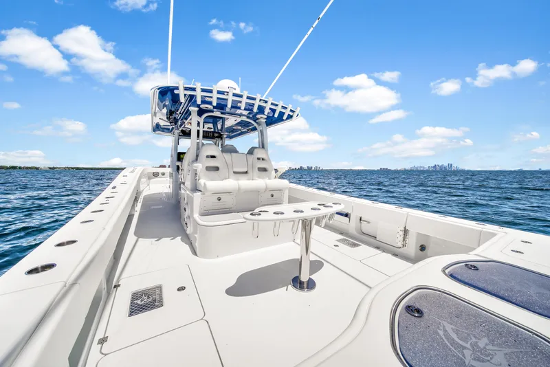 Slide: The Image of 2023 Freeman 47 boat on open water, featuring spacious deck and seating under clear blue sky. - 45