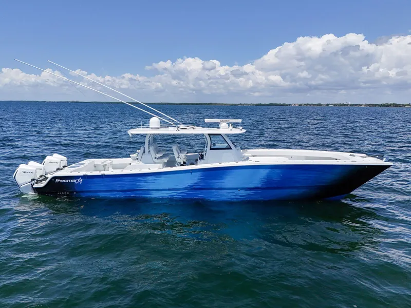 Slide: The Image of 2023 Freeman 47 boat on open water under a clear blue sky. - 7