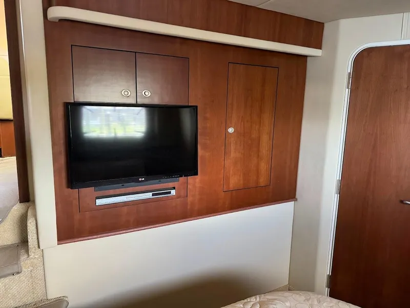 Slide: The Image of 2006 Sea Ray 40 Motor Yacht interior with mounted TV and wooden cabinetry. - 28