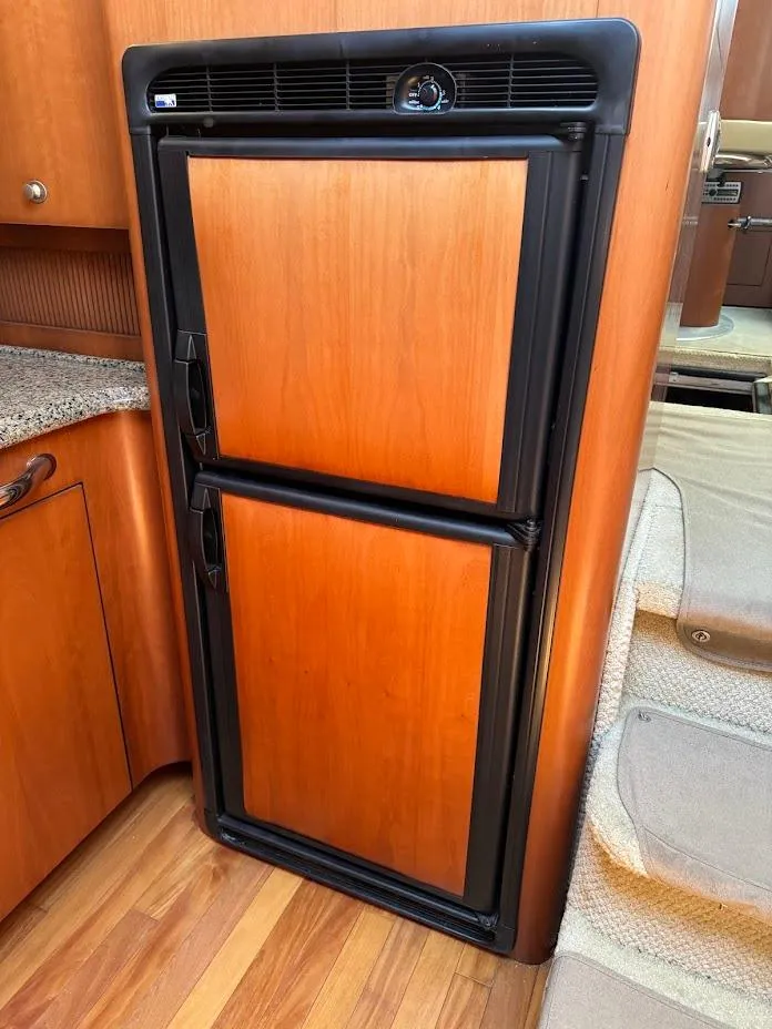 Slide: The Image of 2006 Sea Ray 40 Motor Yacht interior with wooden cabinetry and built-in refrigerator. - 31