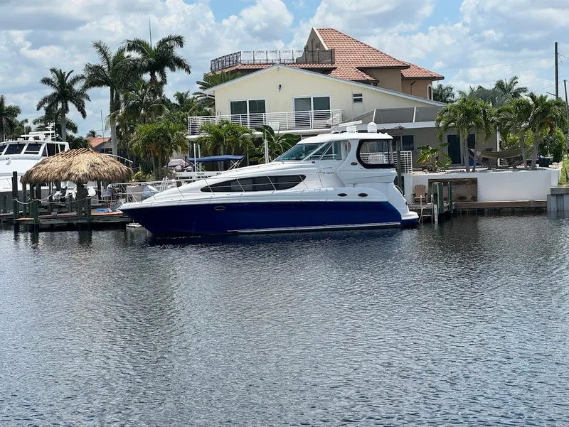 Slide: The Image of 2006 Sea Ray 40 Motor Yacht docked by a waterfront home with palm trees. - 43