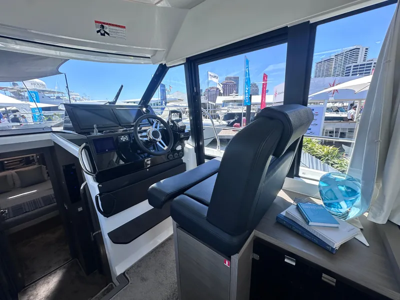 Slide: The Image of Modern Jeanneau 1295 yacht cockpit with sleek design and cityscape view, 2025 model. - 17