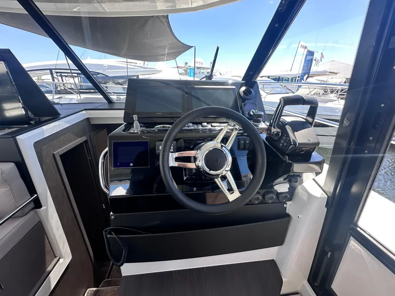 Slide: The Image of Helm of 2025 Jeanneau 1295 yacht with modern steering and navigation controls. - 18