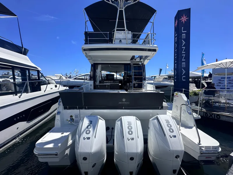 Slide: The Image of 2025 Jeanneau 1295 yacht with triple 300 V8 engines at a boat show. - 3