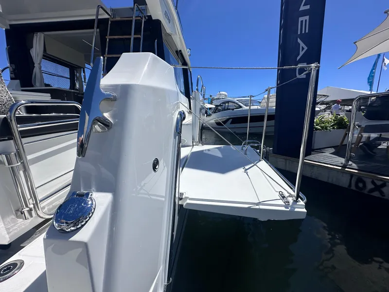 Slide: The Image of 2025 Jeanneau 1295 yacht with open deck and sleek design at marina. - 5