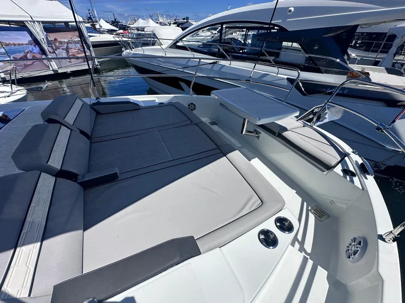 Slide: The Image of 2025 Jeanneau 1295 yacht with spacious deck and luxurious seating at a marina. - 7